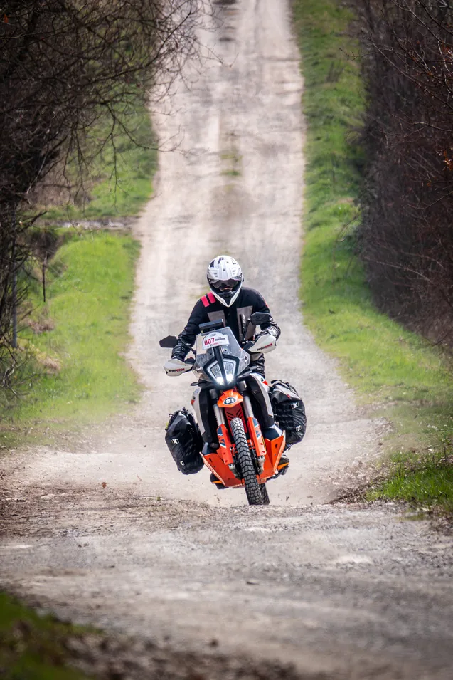 Cimenlerin arasindaki cift izli toprak yolda yuklu motosiklet.